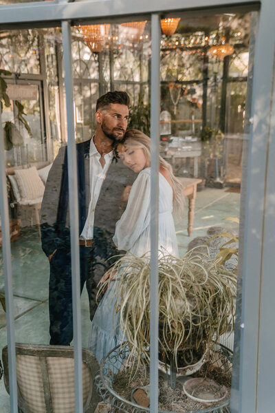 Engaged Couple standing inside glass house taken by Orange County wedding photographer Mikey Mora Photography