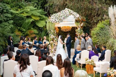 A bride walking up a flower lined staircase