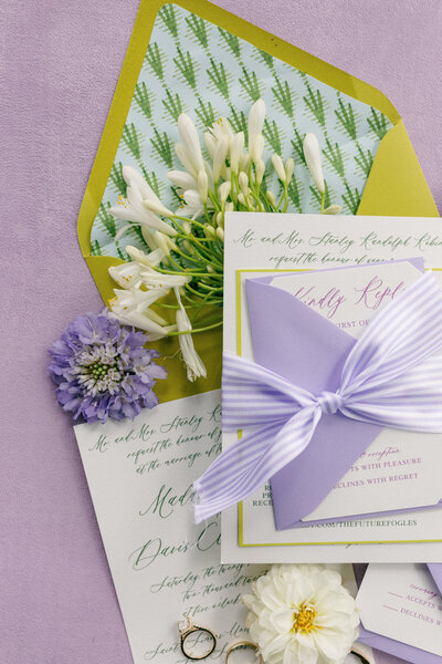 wedding stationery with a purple, green, and yellow color scheme