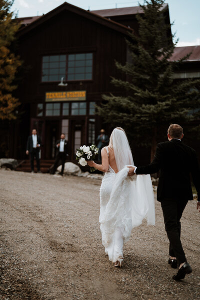 Bride and groom walk toward Ten Mile Station in Breckenridge, photographed by local wedding photographers.