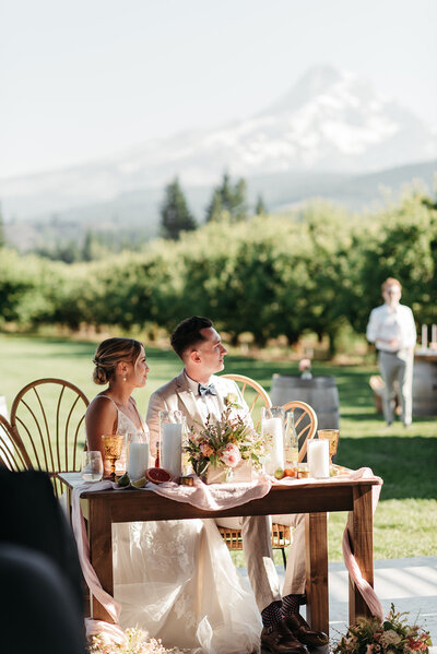 bride and groom sitting at a sweetheart table