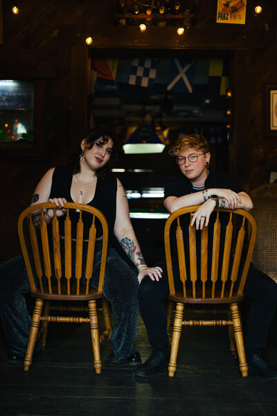 Trans Couple sitting in chairs looking at camera during their Engagement Photo session 