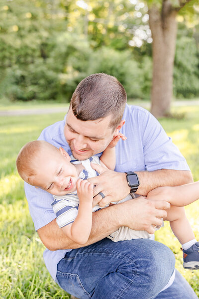 Dad and son tickle fighting in the grass in Russellville, Ohio.