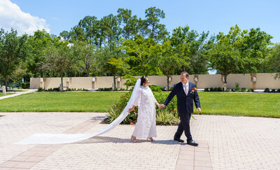 Bride and groom walking hand-in-hand with long veil flowing behind, captured by a romantic Colorado micro-wedding photographer