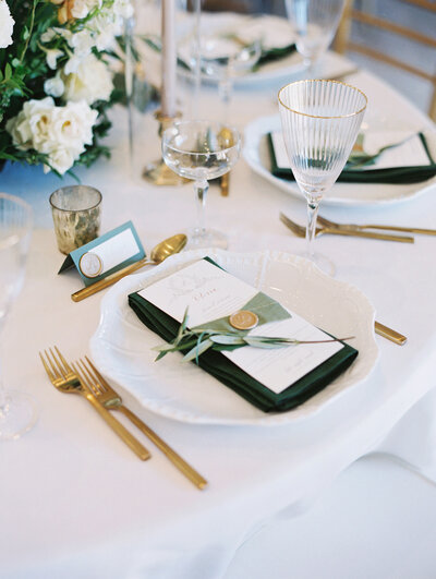 green and white place setting with menu