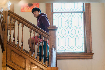man walking up old wooden staircase in historic house