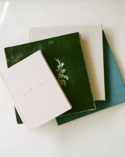 stack of velvet and linen albums from huntsville photographer fauna & film