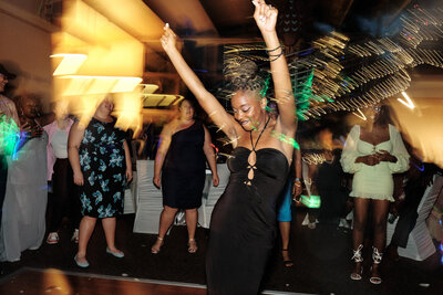 Wedding guest dances with her arms in the air