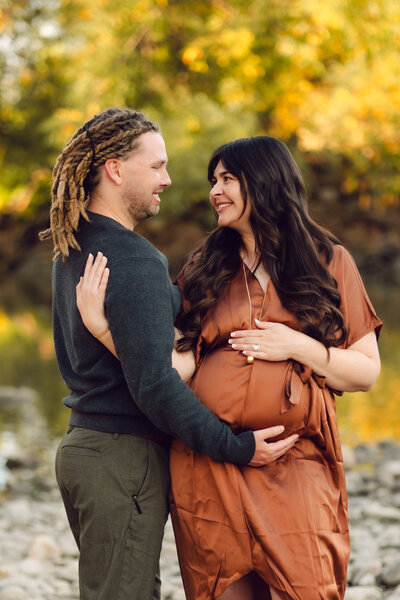 A loving pregnant couple embraces during their maternity shoot in Fort Collins, Colorado, capturing the joy and anticipation of their growing family.