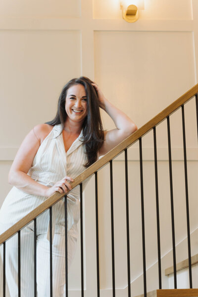 Sarah Wagner Wilmington Realtor for Jacie and Co sitting in chair wearing a white blazer.