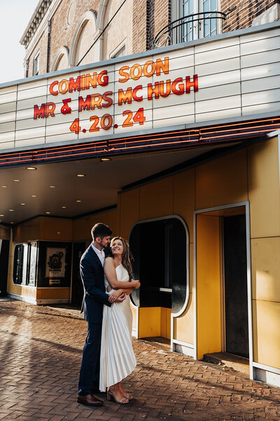 bride and groom outside the movies with their name on the marquee in philadelphia