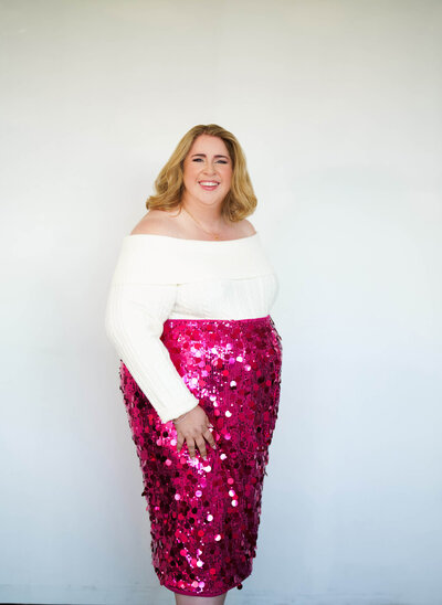 Houstons best wedding photographer Swish and Click smiles for the camera in a white sweater and pink glitter skirt in Houston Texas