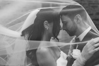 bride and groom sitting on steps surrounded by luxury floral display