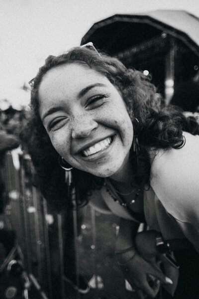 Greyscale closeup picture of a woman smiling at a festival