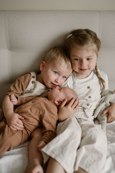 Broer en zus met hun pasgeboren broertje, baby