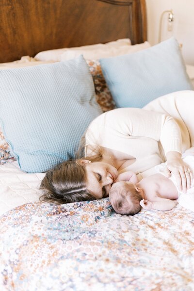 mom and baby laying in bed in little rock in-home newborn photos