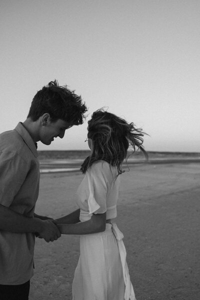 Bride and groom laugh together in front of their wedding venue