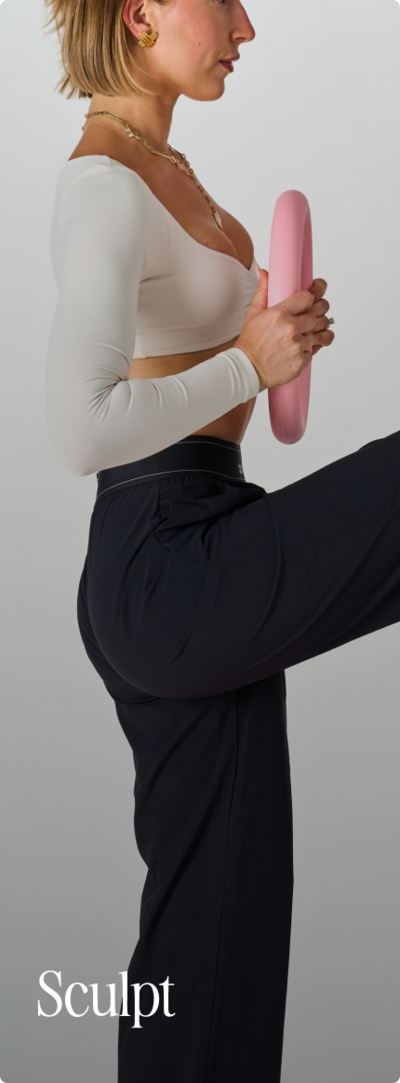 Women holding a Bala circle weight and lifting her knees up and holding weight to chest