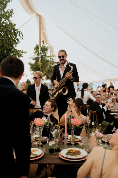 band member playing sax to bride