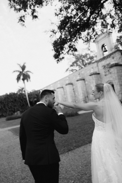 Husband kissing newlywed wife's hand at destination wedding | Sush Digital Media