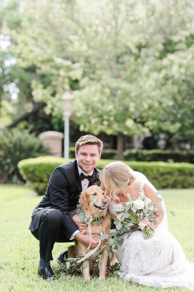bride and groom hugging dog