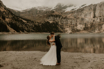 bride and groom kissing while eloping at Oeschinensee Lake in Switzerland