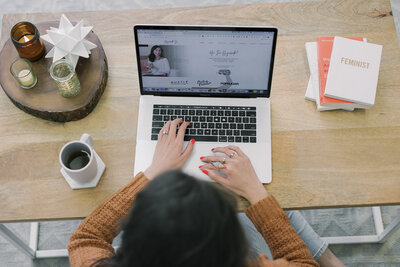 An overhead shot of a woman working from her laptop and desk during her brand photoshoot