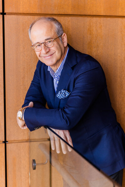 Ahmet Bozer wearing a formal outfit, resting both arm