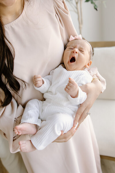 Mom holding yawning baby during newborn photos with  Indianapolis Newborn Photographer, Capturing Simplicity Photography
