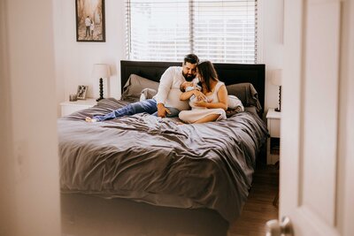 Couple holding their newborn baby in her nursery for an in-home lifestyle newborn photography session. 