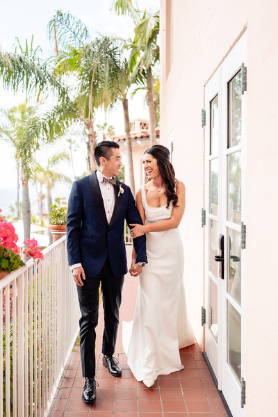 Bride and Groom standing on staircase with long dress at La Valencia wedding venue