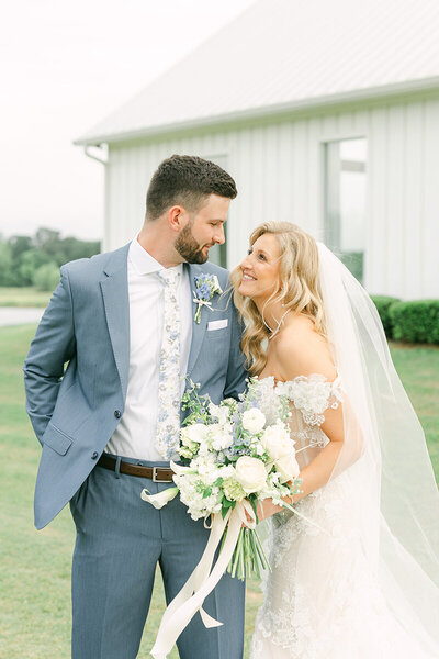 couple cuddling outside the farmhouse