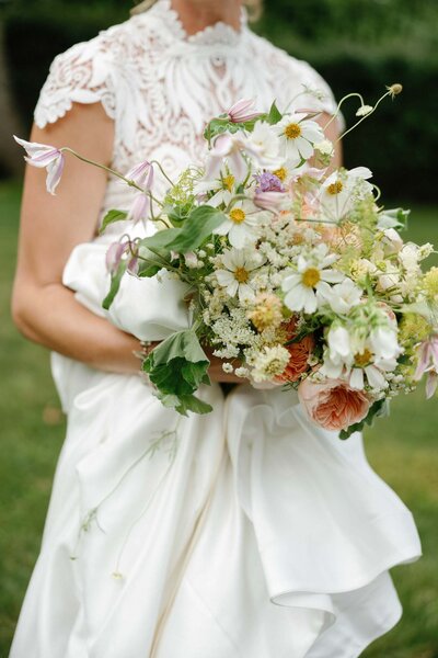 A vibrant bouquet of wildflowers and daisies, showcasing a variety of colors and textures in a natural arrangement.