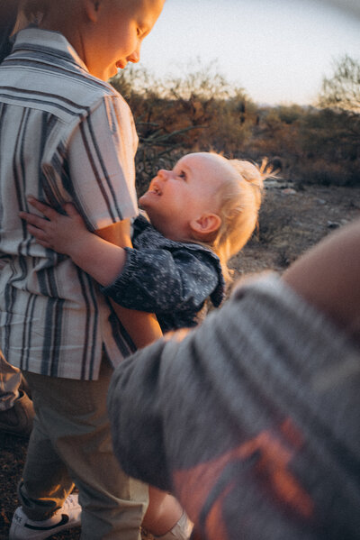 Little sister hugging her brother in the Scottsdale desert