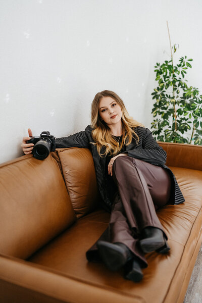 California elopement photographer posing on couch with camera