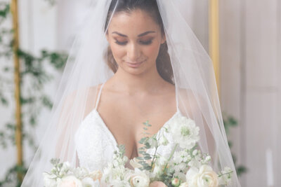 bride looks at her bridal bouquet on her wedding day at Springs Wallaisville in Houston Texas by Swish and Click Photography