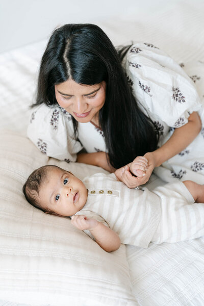 Philly mom holds her newborn baby during her photo session with AnneMarie Hamant