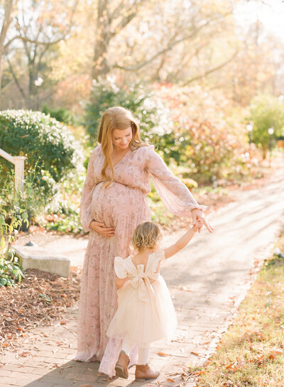 Toddler touching mom's belly during her Raleigh maternity portrait session. Photographed by Raleigh maternity photographer A.J. Dunlap Photography