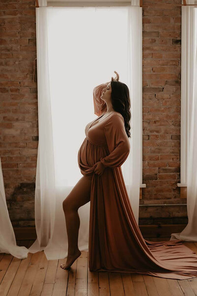 A little girl holding her pregnant mamas belly