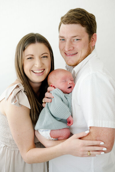 Mary Beth and Cullen smiling and looking with their dog, Marshall