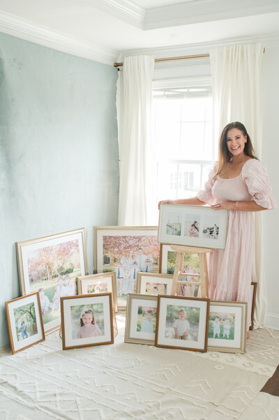Jessica Jeremiah Photography standing with large collection of custom designed heirloom framed prints