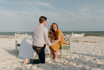 beach proposal of a couple with the water in the background