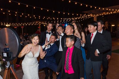 guests posing in front of a photo booth at a wedding reception