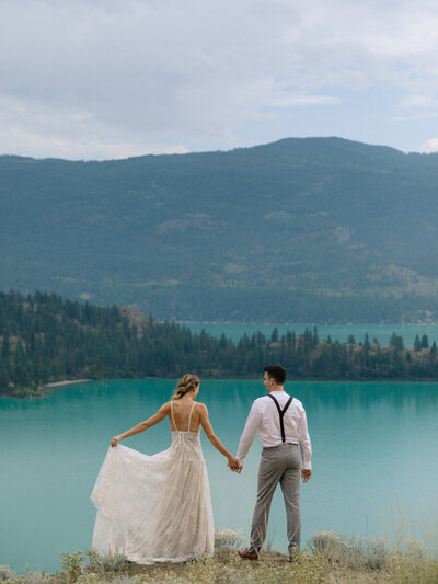 couple in their wedding outfits in front of kalamalka lake