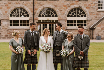 Bride and bridesmaids laughing under confetti at aswanley wedding venue