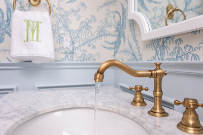 Bold patterned bathroom design with gold mirror