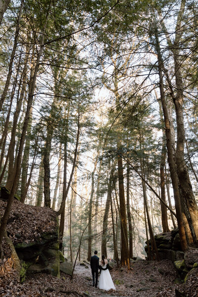Bride and groom walking in a forest in Cuyahoga Valley National Park.