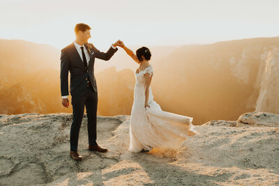 bride & groom dancing on the edge of a cliff