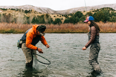 candid photo of couple catching fish while fly fishing the Colorado River