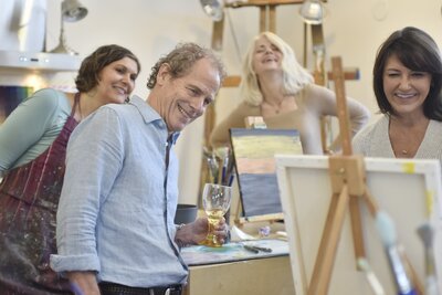 group of people smiling while painting
